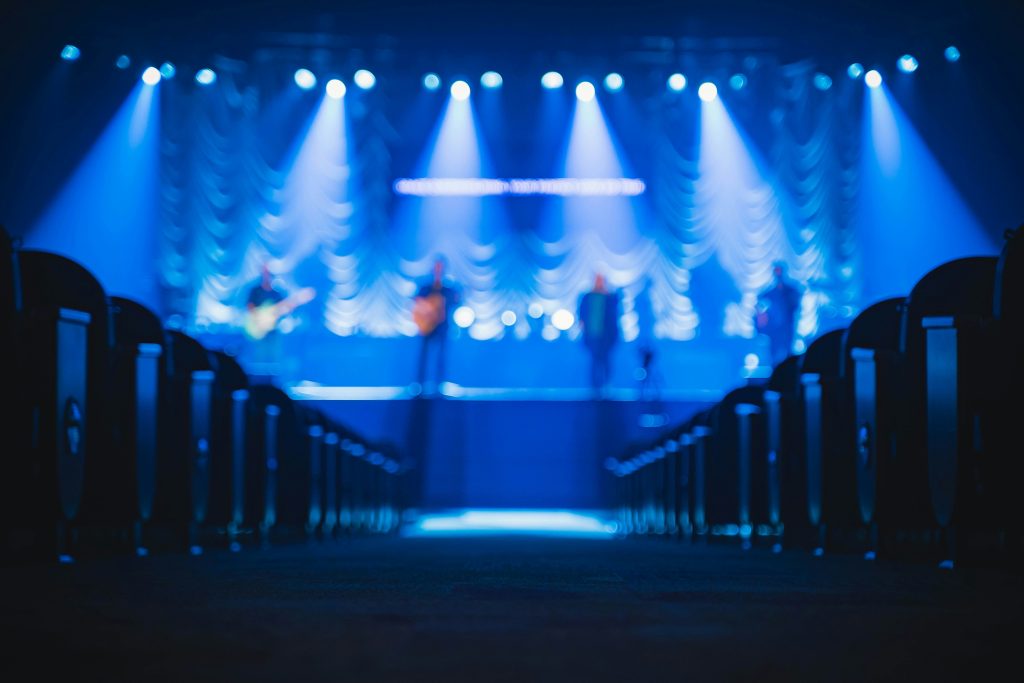 Escenario iluminado al fondo de una sala